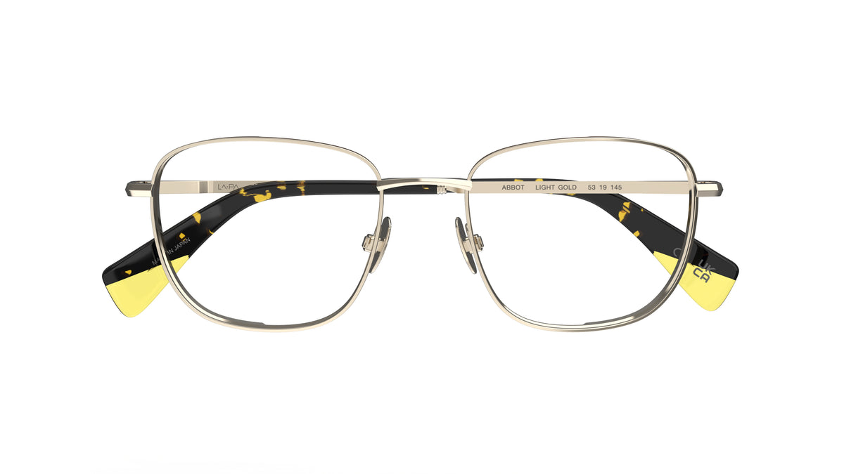 A pair of gold titanium eyeglasses with nosepads, yellow and tortoiseshell temple tips, shown against a plain white background.