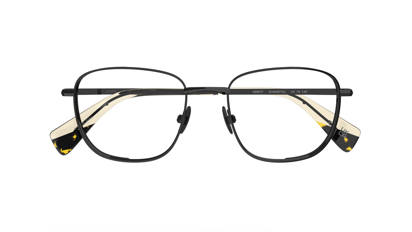 A pair of square gunmetal navigator titanium eyeglass frames with nosepads and cream acetate accents at the temple tips, shown against a plain white background.