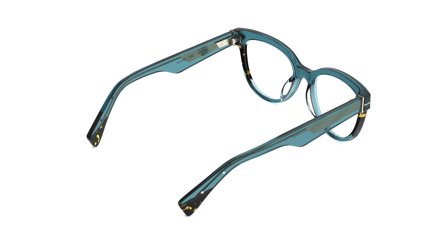 A rear view of a cat-eye eyeglasses in translucent teal acetate with tortoiseshell accents, geometric patterned metal wire core, shown on a plain white background.