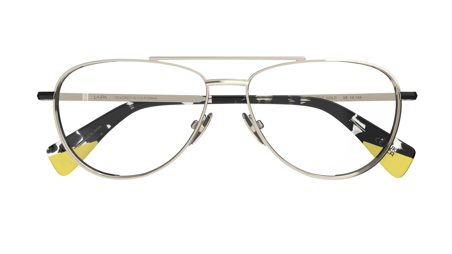 A pair of aviator-style eyeglasses with a light gold titanium construction, black havana and yellow acetate tips on a white background.