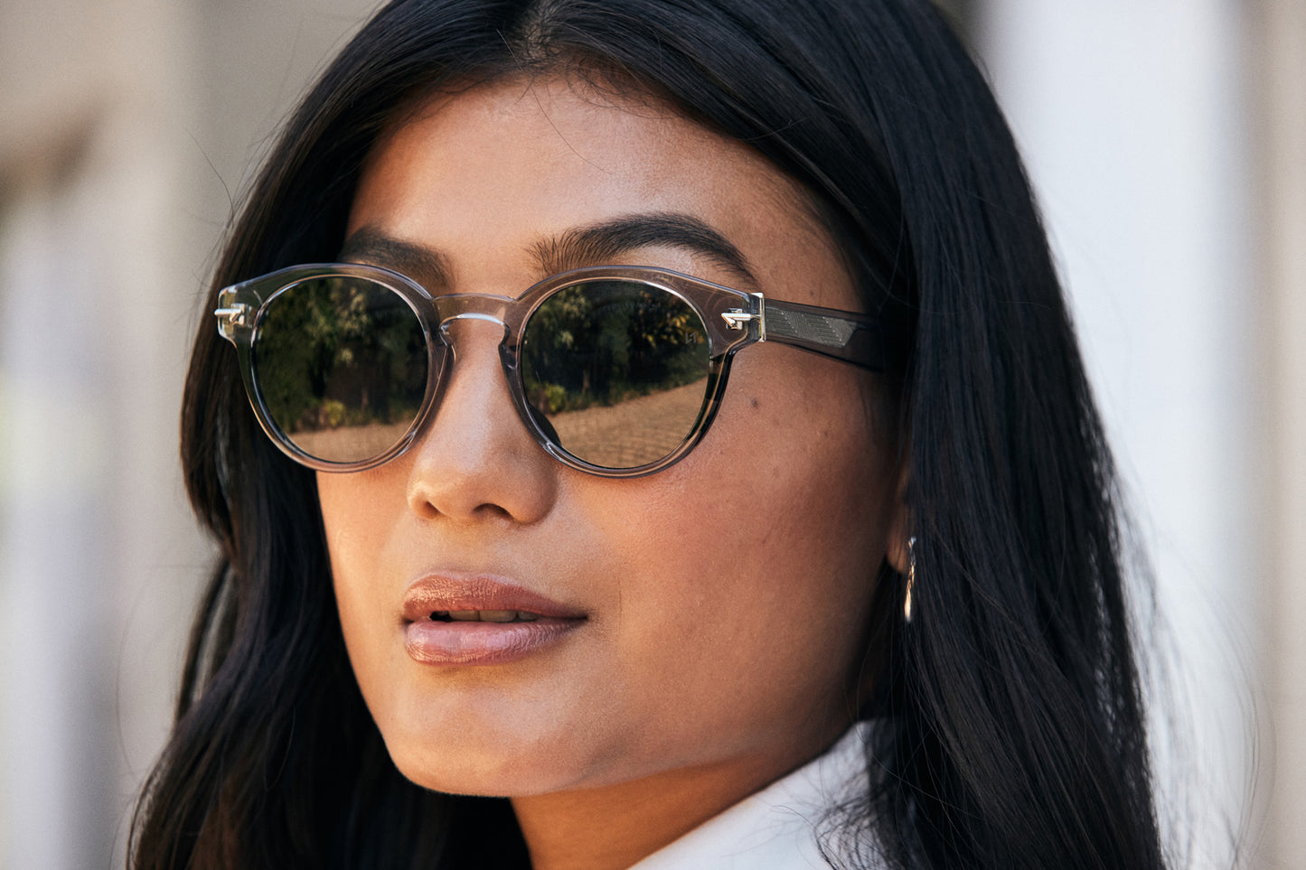 Sophisticated woman wearing a Round Grey Sunglass